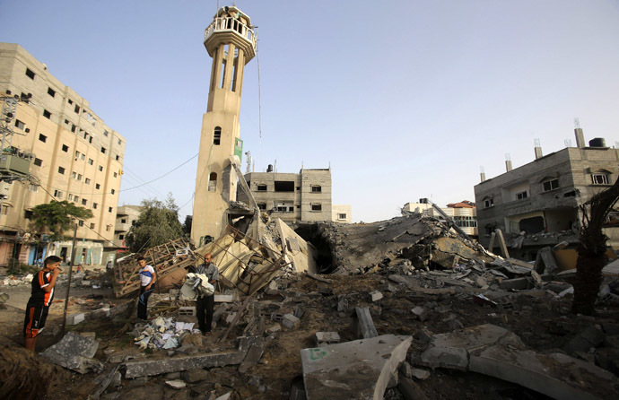 Palestinians survey the rubble of a mosque, which police said was destroyed in an Israeli air strike, in Nuseirat in the central Gaza Strip July 12, 2014. (Reuters/Ibraheem Abu Mustafa)