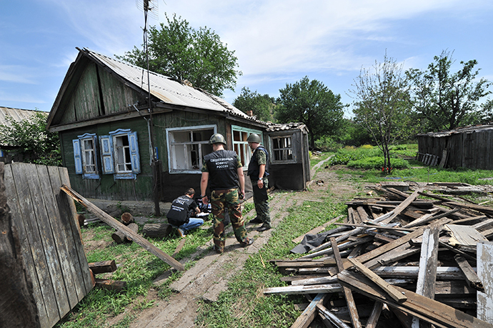 Law enforcement officers work at the area in the town of Donetsk in Russia's Rostov Region which was hit by a high-explosive shell fired from the Ukrainian territory, July 13, 2014. (RIA Novosti / Sergey Pivovarov)