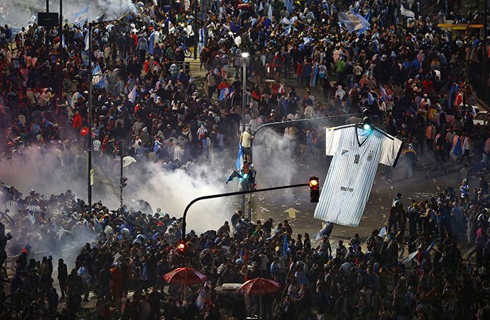 Argentina's fans run away from tear gas as they clash with riot police in Buenos Aires after Argentina lost to Germany in their 2014 World Cup final soccer match in Brazil, July 13, 2014. (Reuters / Ivan Alvarado)