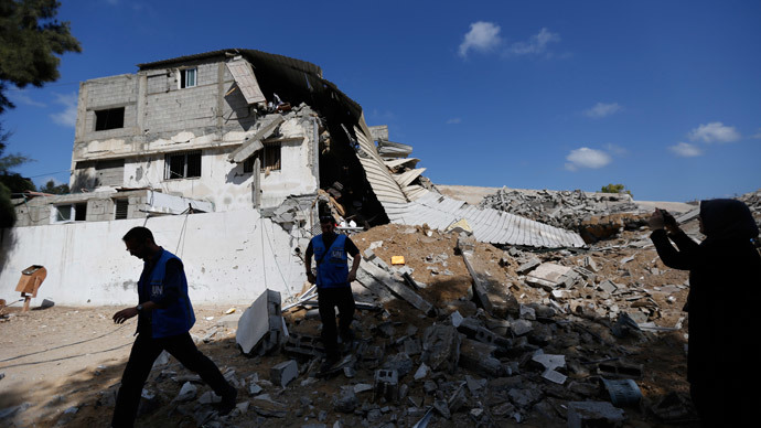 Workers of the United Nations Relief and Works Agency (UNRWA) inspect the rubble of a police station that was hit by an Israeli strike damaging a nearby UNRWA school on July 14, 2014 in Gaza City.(AFP Photo / Mohammed Abed )