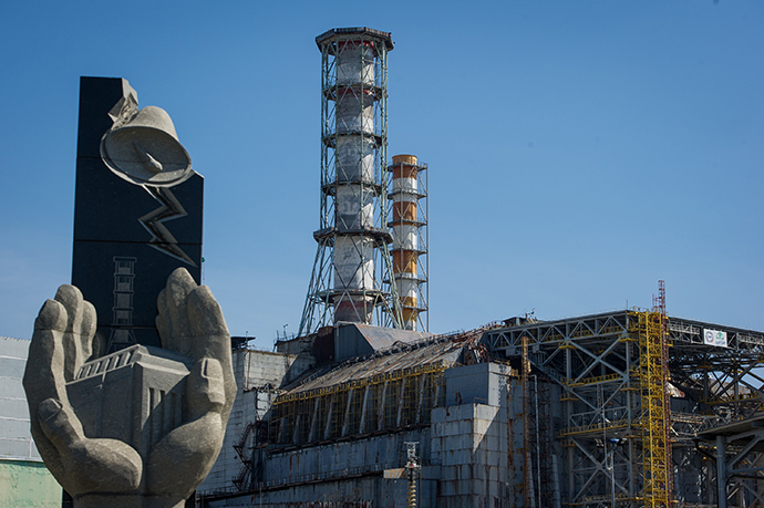 The damaged 4th unit of the Chernobyl Nuclear Power Plant and a memorial sign "Heroes, Professionals - those who protected the world from nuclear disaster" in the Chernobyl Exclusion Zone (RIA Novosti)