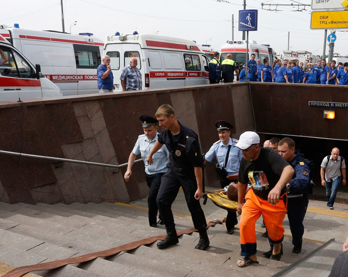 Members of the emergency services carry an injured passenger outside a metro station following an accident on the subway in Moscow July 15, 2014. (Reuters / Sergei Karpukhin)