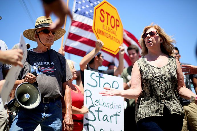 Immigrant rights activist Mary Estrada (R) speaks with anti-immigration activists during a protest outside of the U.S. Border Patrol Murrieta Station on July 7, 2014 in Murrieta, California. (AFP Photo / Getty Images / Sandy Huffaker)