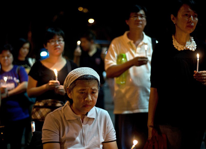 People gather during a candle-light vigil for the victims of the Malaysia Airlines flight MH17, in Kuala Lumpur on July 19, 2014. (AFP Photo / Manan Vatsyayana)