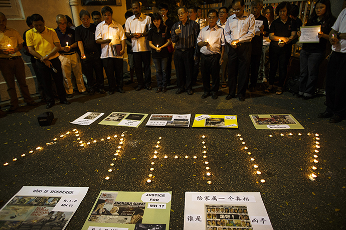 People hold candles during a candlelight vigil for victims of the downed Malaysia Airlines Flight MH17, in Kuala Lumpur July 19, 2014. (Reuters / Athit Perawongmetha)