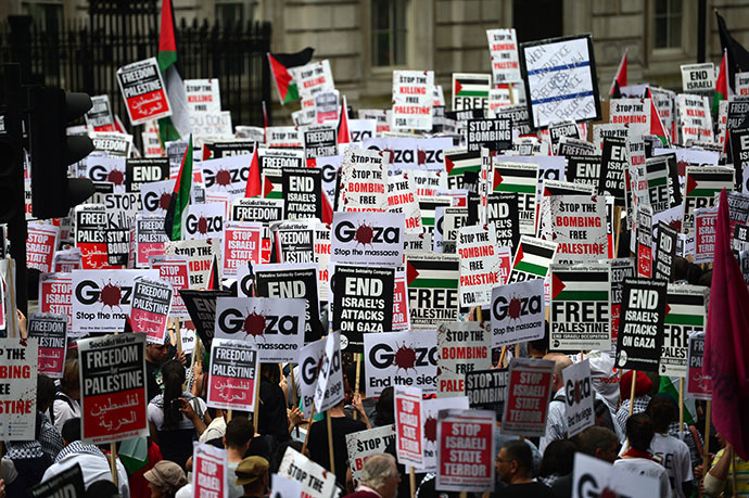 Protesters display placards and banners as they take part in demonstration against Israeli airstrikes in Gaza in central London on July 19, 2014 against Gaza strikes. (AFP Photo / Carl Court)