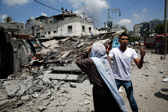Palestinians react to destroyed homes in the Shejaia neighbourhood, which was heavily shelled by Israel during fighting, in Gaza City July 20, 2014 (Reuters / Finbarr O'Reilly)