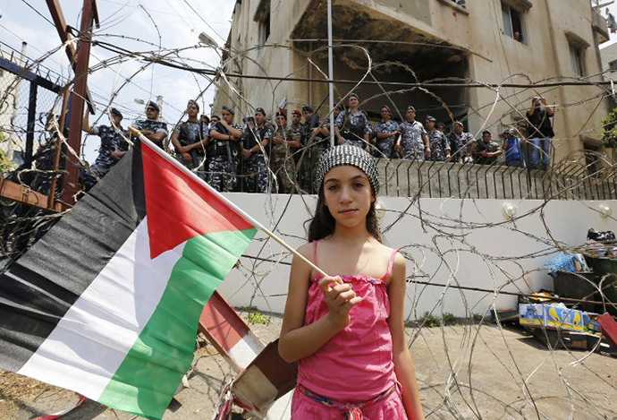 A girls holds up the Palestinian flag during a protest near the US embassy in Awkar, on the outskirts of the Lebanese capital Beirut, on July 20, 2014, against the Israeli military offensive on the Palestinian Gaza Strip. (AFP Photo / Anwar Amro)