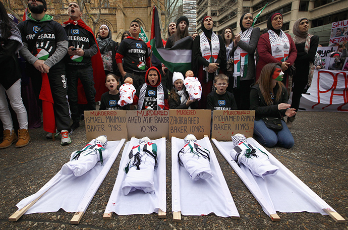 Children sit in front of dolls on stretchers as they and other members of the Australian Palestinian community hold a protest against Israel's military action in Gaza, in Sydney July 20, 2014. (Reuters / David Gray)