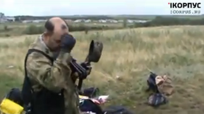 A member of Donetsk self-defense forces takes off his cap and crosses himself to pay tribute to the victims of the Malaysia plane crash (screenshot from infrocorpus)