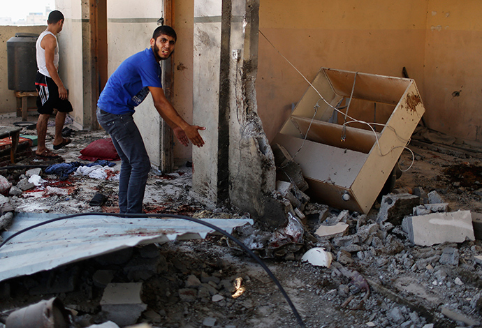 Palestinians inspect a damaged house which police said was hit by an Israeli shelling that killed 8 members from al-Qassas family, among them four children, in Gaza City July 21, 2014 (Reuters / Suhaib Salem)