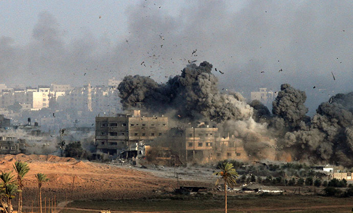 Debris and smoke fill the air during an Israeli strike on Gaza City early on July 26, 2014. (AFP Photo / Gil Cohen Magen)