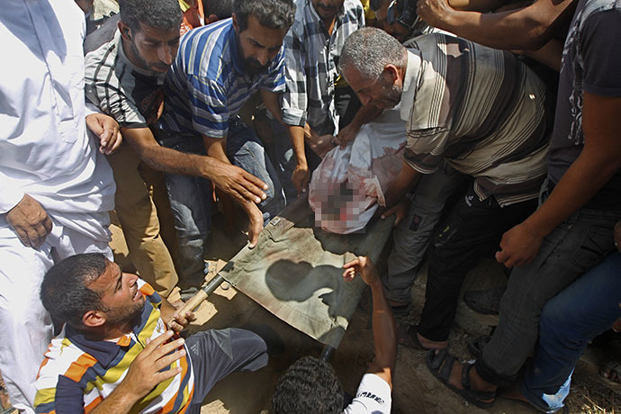 Palestinian relatives bury one of several children from the al-Najjar (Najar) family, killed in an Israeli air strike on their house in Khan Yunis, in the southern Gaza Strip, on July 26, 2014. (AFP Photo / Said Khatib)