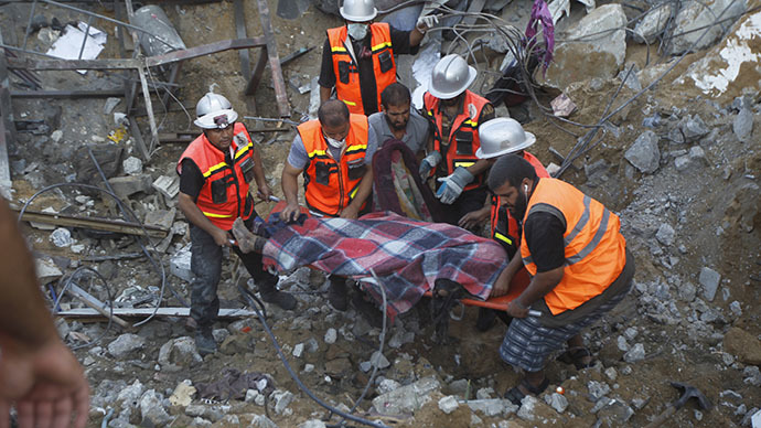 Rescue workers carry the body of a member of al-Najar family, after removing it from under the rubble of their home following an Israeli air strike on Khan Yunis in the southern of Gaza strip, on July 26, 2014. (AFP Photo / Said Khatib)