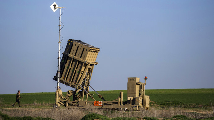 An Israeli soldier walks near the launcher of an Iron Dome missile interceptor battery deployed in the southern Israeli coastal city of Ashkelon (Reuters/Amir Cohen)