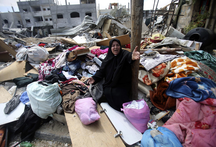 A Palestinian woman reacts as she collects her belongings from her house which witnesses said was destroyed in an Israeli air strike, in Rafah in the southern Gaza Strip August 4, 2014. (Reuters / Ibraheem Abu Mustafa)