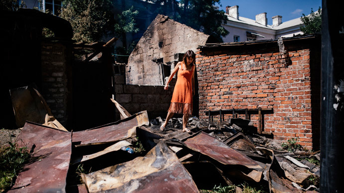 A woman walks through wreckage after shelling in Donetsk on August 9, 2014.(AFP Photo / Dimitar Dilkoff)