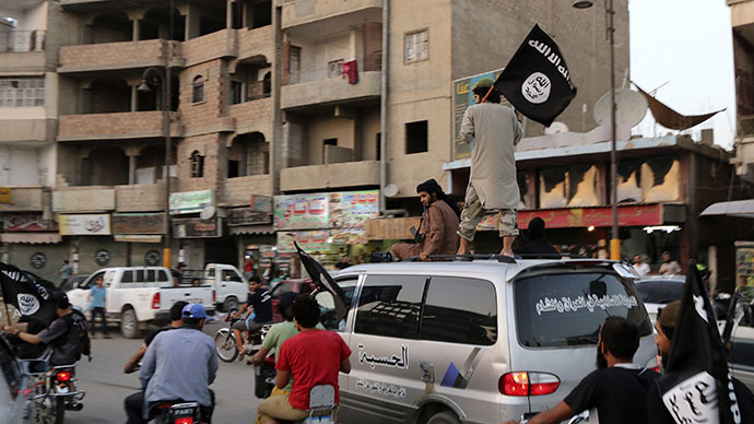 Members loyal to the Islamic State in Iraq and the Levant (ISIL) wave ISIL flags as they drive around Raqqa June 29, 2014. (Reuters)