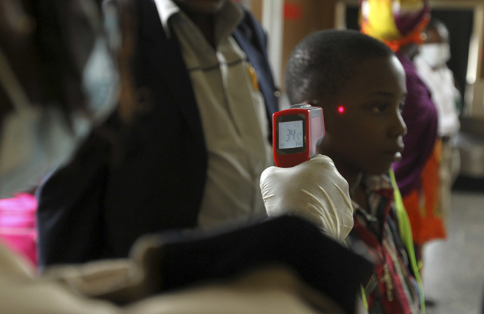A boy's temperature is taken using an infrared digital laser thermometer at the Nnamdi Azikiwe International Airport in Abuja, August 11, 2014. (Reuters/Afolabi Sotunde)