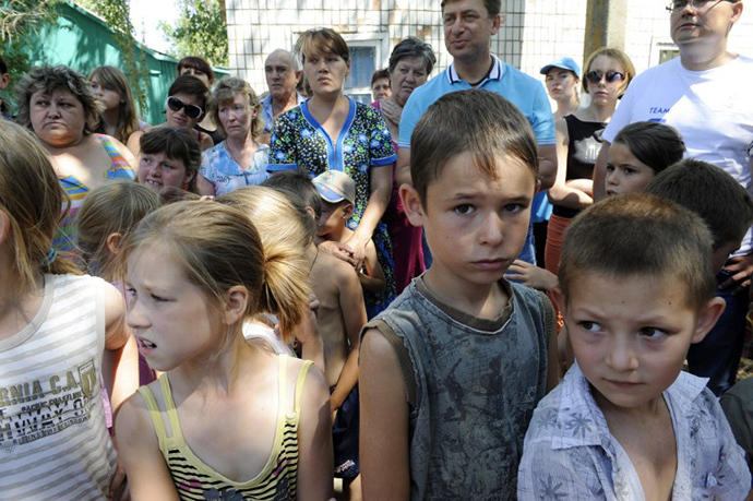 Women with their children, refugees from Donetsk and Lugansk regions, queue to receive humanitarian aid from the UN mission in Yalta, some 142 km from eastern Ukrainian city of Donetsk, on August 2, 2014. (AFP Photo / Alexander Khudoteply)