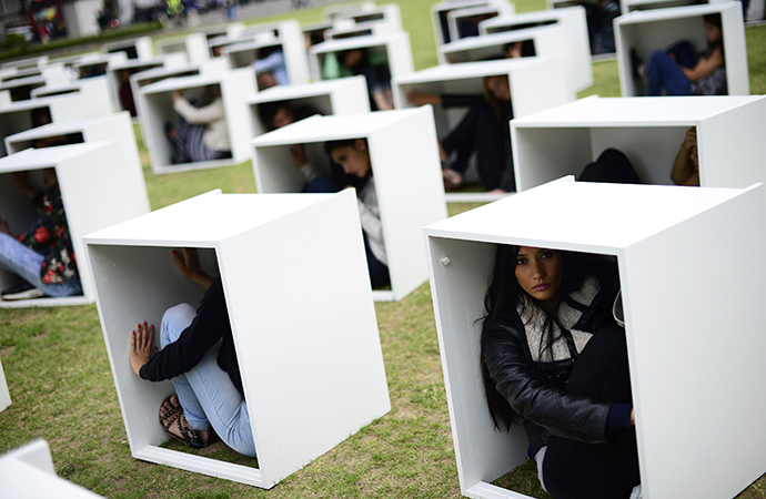 Volunteers sit in wooden boxes at Parliament Square, to represent living conditions in Gaza, during a protest in London August 14, 2014. (Reuters / Dylan Martinez)