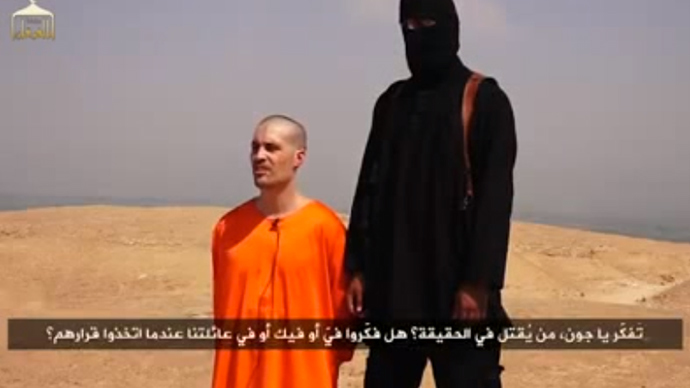 An American Journalist, James Foley, is seen kneeling adjacent to a masked Islamic State (IS) militant prior to his alleged brutal beheading with a knife. (Screenshot from youtube.com/user/majed0001)