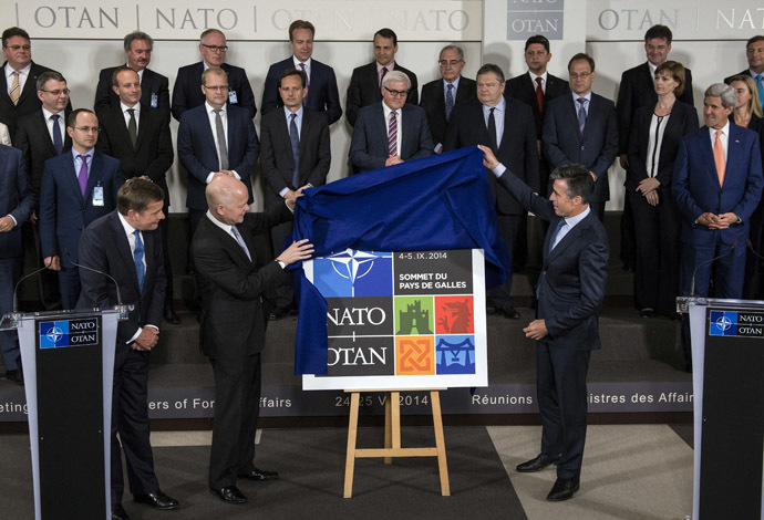 British Foreign Secretary of State for Foreign and Commonwealth Affairs William Hague (L) and NATO Secretary General Anders Fogh Rasmussen (R) unveil the logo for the upcoming NATO summit in Wales during a family photo of NATO Foreign Affairs ministers at the NATO headquarters in Brussels on June 25, 2014. (AFP Photo)