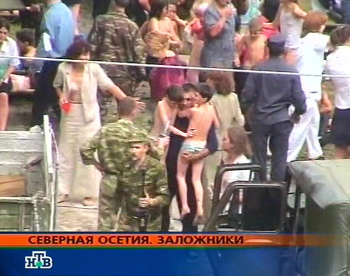 This TV-grab image taken from Russian NTV channel shows hostages in the school garden during the rescue operation in the town of Beslan, North Ossetia 03 September 2004. (AFP/NTV)