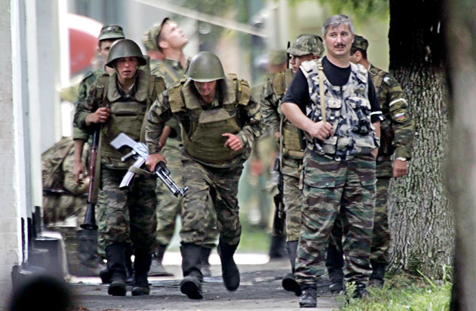 Russian soldiers take position outside the school, where a group of gunmen, wearing belts laden with explosives, are holding hostage some 350 people in the northern Ossetian town of Beslan, some 30 kms outside Vladikavkaz, 02 September 2004. (AFP/ITAR-TASS)