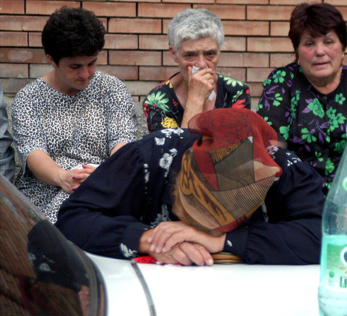 Relatives of school children being held hostage wait for further developments as they sit near the seized school in the town of Beslan, province of North Ossetia near Chechnya, September 1, 2004. (Reuters)