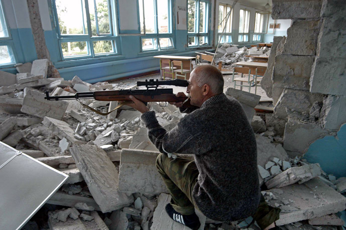 An Ossetian militiaman aims from a boarding school, at the opposite school, where a group of gunmen, wearing belts laden with explosives, are holding hostage some 350 people in the northern Ossetian town of Beslan, some 30 kms outside Vladikavkaz, 02 September 2004. (AFP/ITAR-TASS)