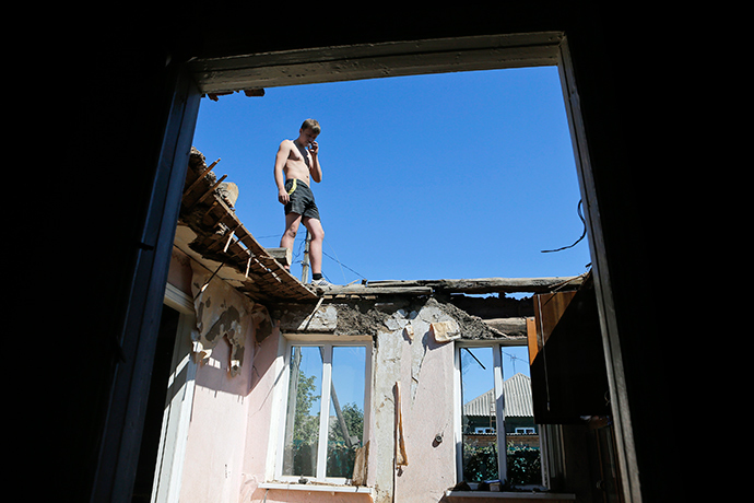 A man stands at the top of a house destroyed during the recent shelling in the eastern Ukrainian town of Ilovaysk, August 31, 2014 (Reuters / Maxim Shemetov)