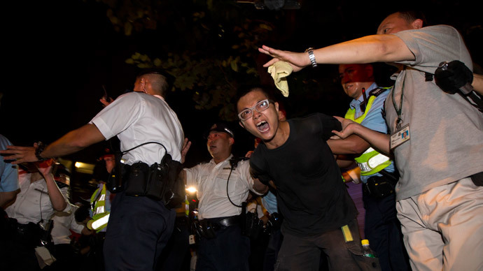 A pro-democracy activist is detained by the police during a confrontation outside the hotel where China's National People's Congress (NPC) Standing Committee Deputy General Secretary Li Fei is staying, in Hong Kong September 1, 2014.(Reuters / Tyrone Siu )