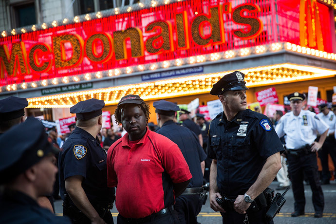 A protester demanding higher wages and unionization for fast food workers is arrested by police near Times Square on September 4, 2014 in New York City. (AFP Photo / Andrew Burton)
