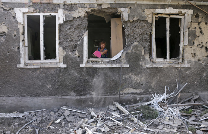 A woman cleans debris from her house damaged by what locals say, was recent shelling by Ukrainian forces in Donetsk August 23, 2014. (Reuters/Maxim Shemetov)