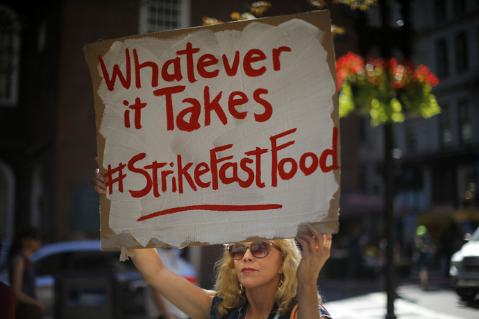 A woman holds a sign reading "Whatever it Takes" during a protest for higher wages in Boston, Massachusetts September 4, 2014. (Reuters/Brian Snyder)