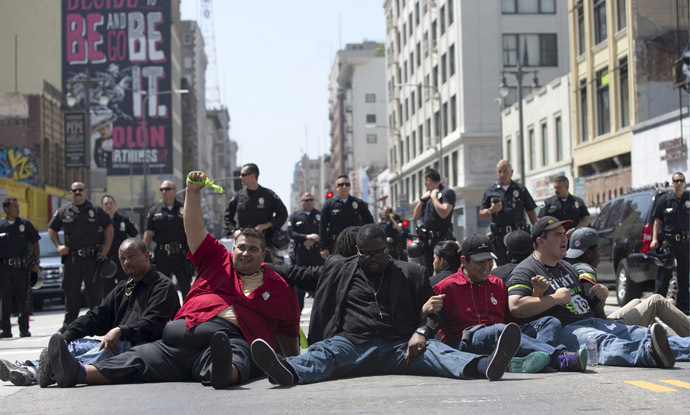 Activists sit in the street during a protest demanding better wages for fast-food workers in Los Angeles, California September 4, 2014. (Reuters/Mario Anzuoni)