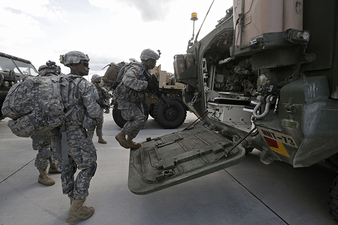 U.S.173 airborne brigade soldiers climb onto armoured personal carrier "Stryker" during the "Steadfast Javelin II" military exercise in the Lielvarde air base, September 6, 2014. (Reuters / Ints Kalnins)
