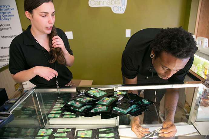 Employees stock shelves at Cannabis City before their "high noon" grand opening during the first day of legal retail marijuana sales in Seattle, Washington July 8, 2014 (Reuters / Jason Redmond)