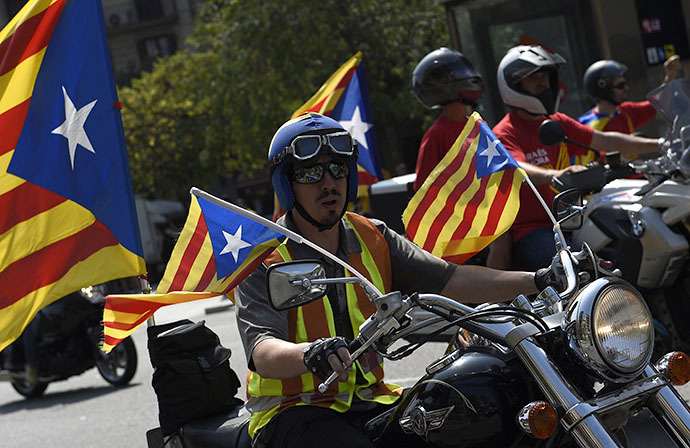 A biker with an independentist flag rides through Barcelona during Catalonia National Day (Diada) on September 11, 2014. (AFP Photo / Lluis Gene)