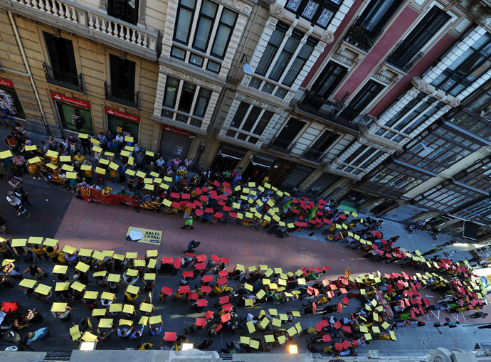 People hold placards with the colours of the Catalan flag as they take part in a demonstration in support of a Catalan vote on independence from Spain, in the northern Spanish Basque city of Bilbao on September 9, 2014, ahead of the Diada. (AFP Photo/Rafa Rivas)