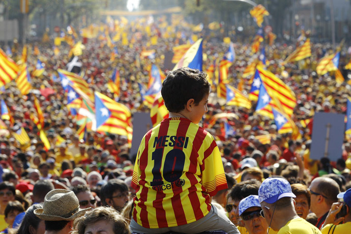 A boy wearing Lionel Messi's jersey sits on the shoulders of a relative as Catalans holding independentist flags (Estelada) gather on Gran Via de les Corts Catalanes during celebrations of Catalonia National Day (Diada) in Barcelona on September 11, 2014. (AFP Photo/Quique Garcia)