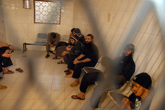 Some of the ten alleged Al-Qaeda members sit in a holding-room in court during their hearing in the Yemeni capital Sanaa (AFP Photo / Gamal Noman)