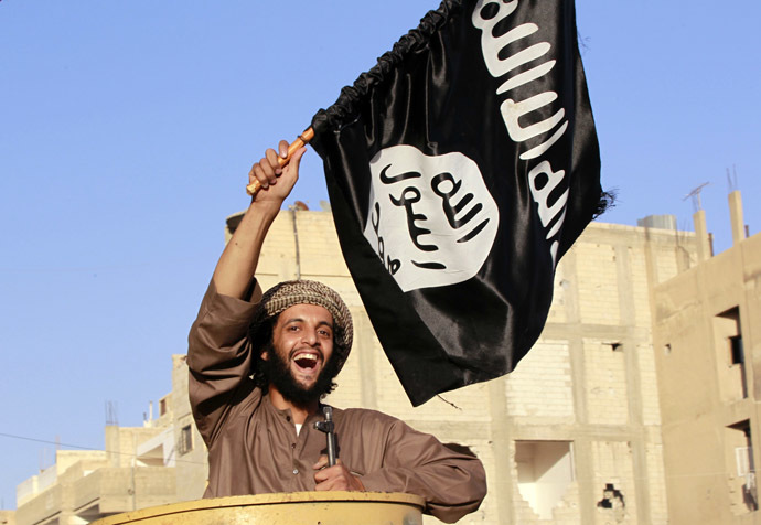 A militant Islamist fighter waving a flag, cheers as he takes part in a military parade along the streets of Syria's northern Raqqa province June 30, 2014. (Reuters)