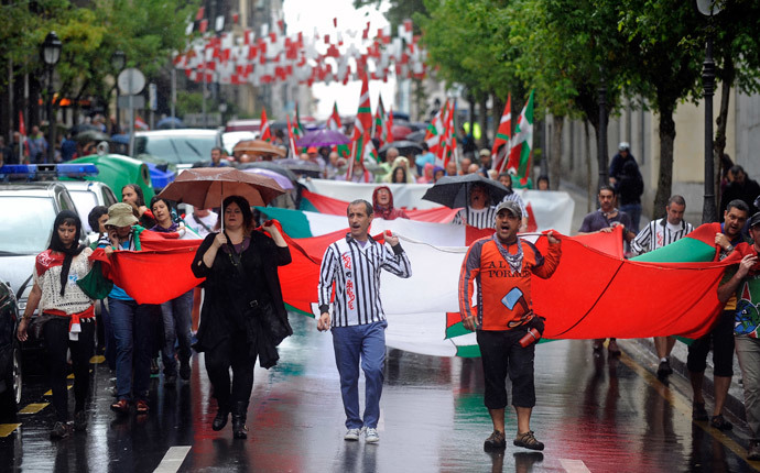 Pro independence demonstrators carry a big Ikurrina (Basque flag) as they protest in favour of the Basque flag (Ikurrina) and against the Spanish flag during the local festivities of the northern Spanish Basque city of Bilbao (AFP Photo / Rafa Rivas)