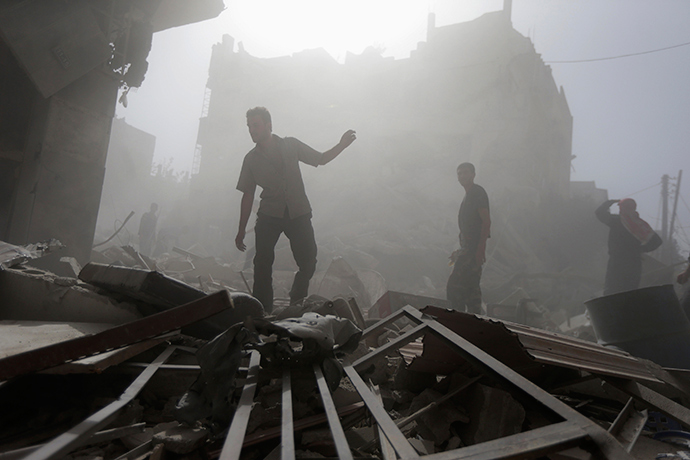 Residents inspect a damaged site after what activists say were four air strikes by forces loyal to Syria's President Bashar al-Assad in Douma, eastern al-Ghouta, near Damascus September 24, 2014 (Reuters / Bassam Khabieh)