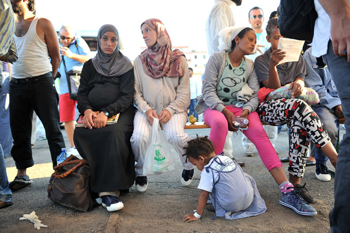Immigrants, part of a group of more than 1,370 people, wait after they disembarked from the Italian military ship "San Giusto" on August 25, 2014. (AFP Photo/Alfonso Di Vincenzo)