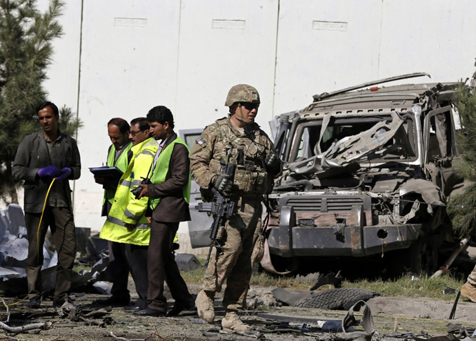 A U.S. soldier and local men carry out an investigation at the site of a suicide attack in Kabul September 16, 2014. (Reuters/Omar Sobhani)