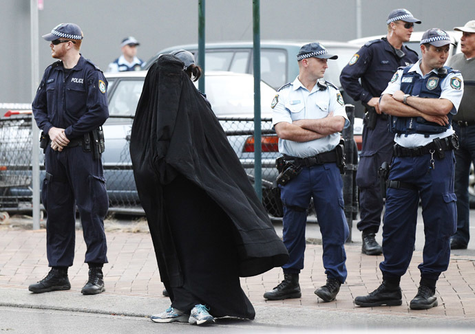 Police officers stand on guard next to a woman wearing a burqa near the venue where controversial Dutch member of parliament Geert Wilders will speak in the Sydney suburb of Liverpool February 22, 2013. (Reuters/Daniel Munoz)