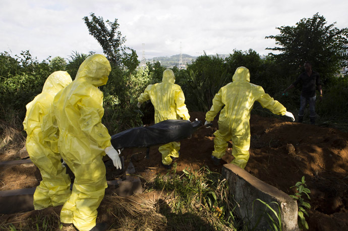 A burial team wearing protective clothing prepare the body of a person suspected to have died of the Ebola virus for interment, in Freetown September 28, 2014. (Reuters/Christopher Black)